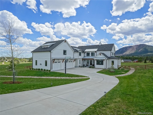modern farmhouse style home featuring board and batten siding, an attached garage, driveway, and a front yard