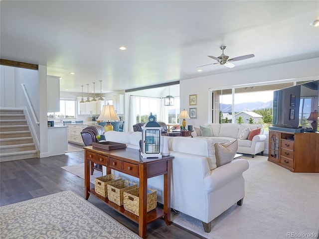 living area featuring recessed lighting, a ceiling fan, wood finished floors, and stairway