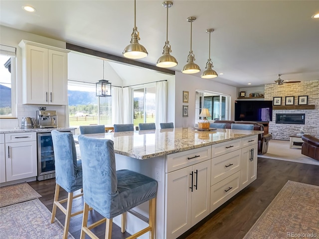 kitchen with a center island, pendant lighting, white cabinets, and a breakfast bar