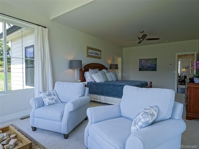 bedroom featuring a ceiling fan, visible vents, multiple windows, and carpet