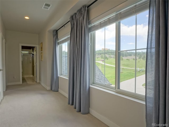 hallway featuring visible vents, recessed lighting, baseboards, and light carpet