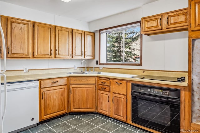 kitchen featuring black appliances, dark tile patterned floors, and sink