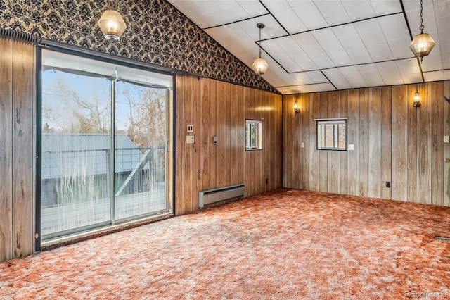 unfurnished living room featuring carpet flooring, a wealth of natural light, wooden walls, and a baseboard radiator