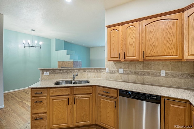 12710 Jasmine St Unit C, Thornton, CO 80602 - kitchen featuring a sink, a peninsula, wood finished floors, tasteful backsplash, and stainless steel dishwasher