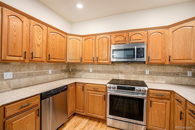 12710 Jasmine St Unit C, Thornton, CO 80602 - kitchen with light wood-style flooring, appliances with stainless steel finishes, and brown cabinets