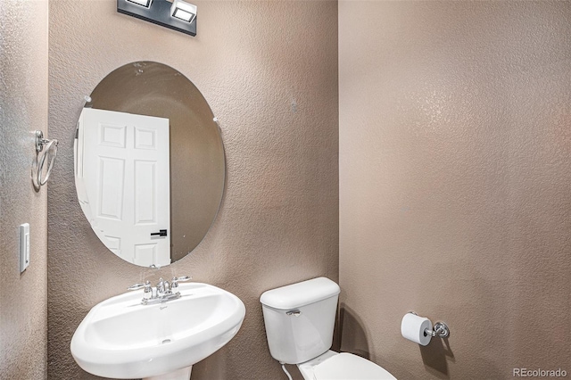 12710 Jasmine St Unit C, Thornton, CO 80602 - half bath featuring toilet, a textured wall, and a sink