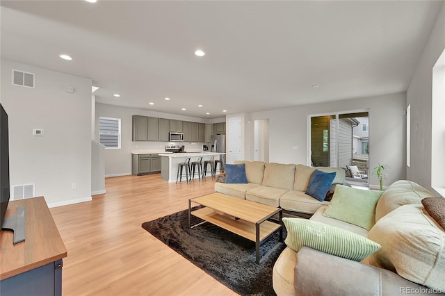 living room with light wood finished floors, a wealth of natural light, and recessed lighting