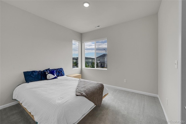 carpeted bedroom with visible vents and baseboards