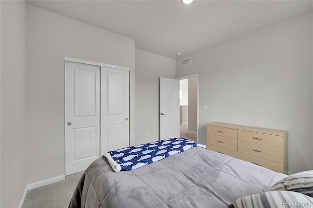 carpeted bedroom featuring a closet, visible vents, and baseboards