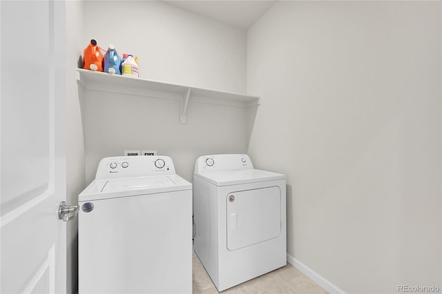 laundry area featuring laundry area, washing machine and clothes dryer, and baseboards