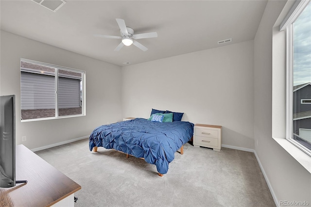 bedroom featuring light carpet, baseboards, visible vents, and a ceiling fan