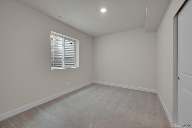 spare room featuring light carpet, recessed lighting, visible vents, and baseboards