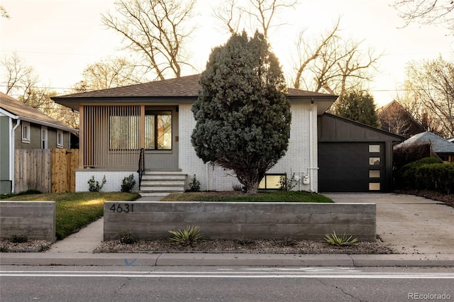 4631 Zuni St, Denver, CO 80211 - view of front facade with brick siding, driveway, a garage, fence, and a shingled roof