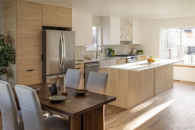 4631 Zuni St, Denver, CO 80211 - kitchen featuring appliances with stainless steel finishes, a sink, healthy amount of natural light, and tasteful backsplash