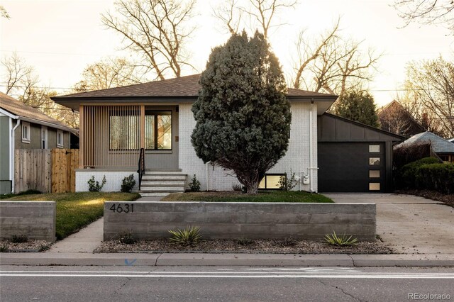 4631 Zuni St, Denver, CO 80211 - view of front facade featuring brick siding, concrete driveway, a garage, and fence