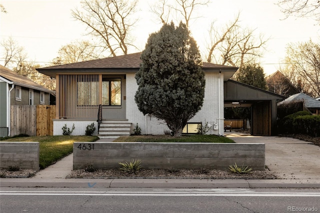 4631 Zuni St, Denver, CO 80211 - view of front facade with brick siding, a carport, concrete driveway, and fence