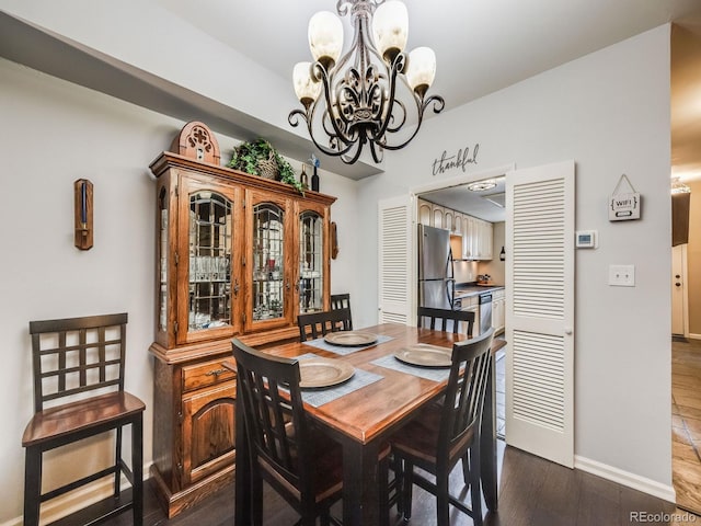 dining room with baseboards, dark wood finished floors, and a chandelier