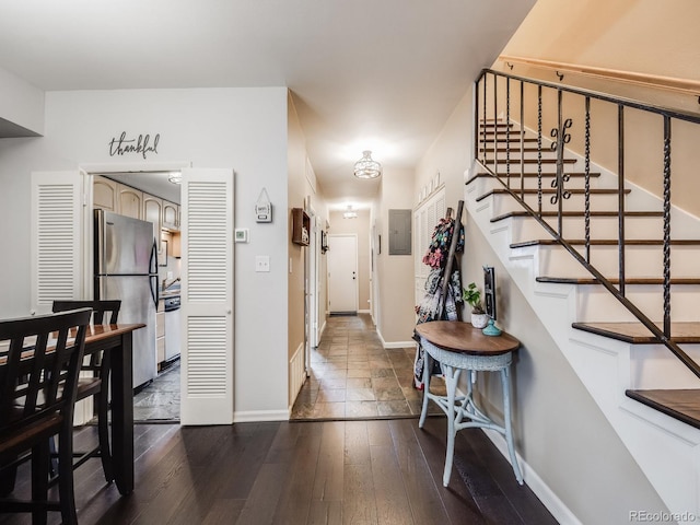 foyer featuring stairs, dark wood-type flooring, and baseboards