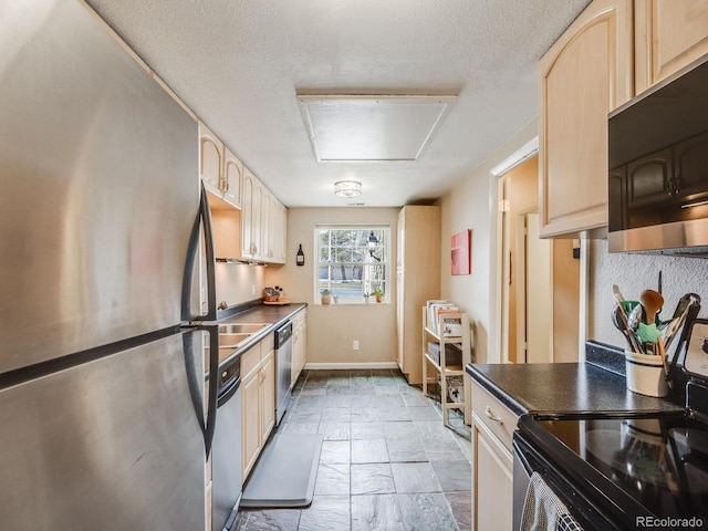 kitchen with dark countertops, light brown cabinets, a textured ceiling, and black appliances