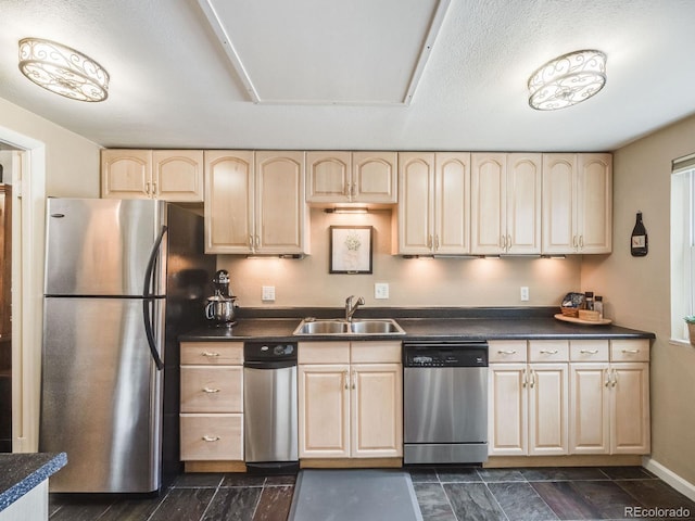 kitchen with appliances with stainless steel finishes, light brown cabinets, and a sink