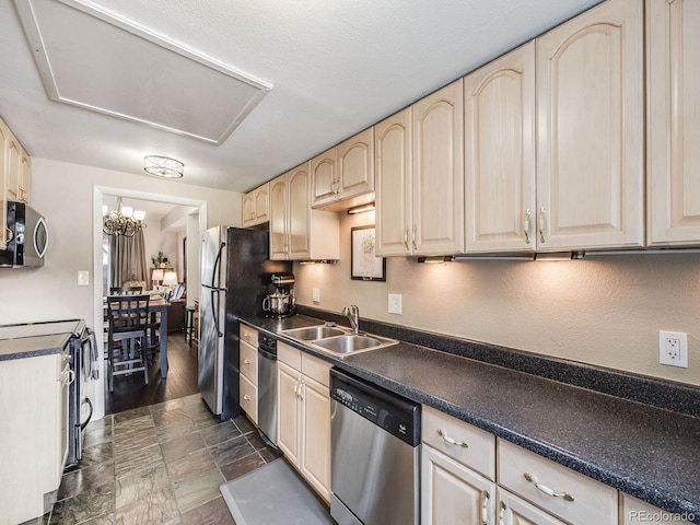 kitchen with stainless steel appliances, dark countertops, light brown cabinets, and a sink