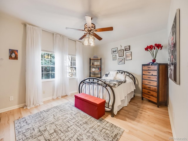 bedroom featuring ceiling fan, light wood finished floors, and baseboards