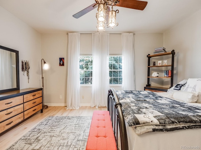 bedroom with light wood finished floors, ceiling fan, and baseboards