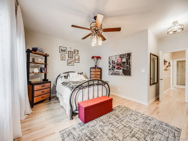 bedroom with ceiling fan, light wood finished floors, and baseboards