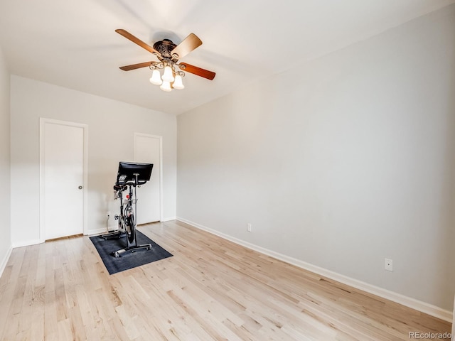 exercise area with a ceiling fan, light wood-style flooring, and baseboards