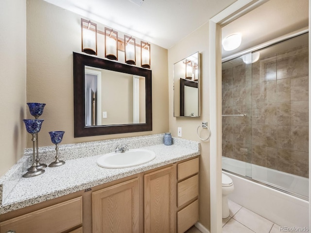 full bath with tile patterned flooring, combined bath / shower with glass door, vanity, and toilet