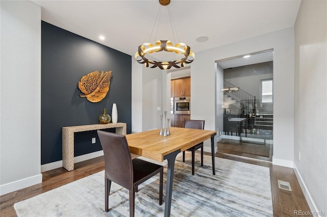 16371 Jones Mountain Way, Broomfield, CO 80023 - dining area with a chandelier, wood finished floors, and baseboards