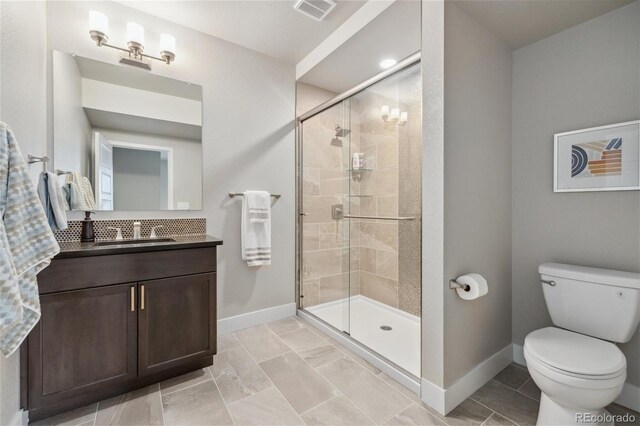 16371 Jones Mountain Way, Broomfield, CO 80023 - bathroom featuring baseboards, vanity, a shower stall, toilet, and tasteful backsplash