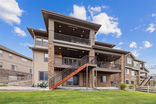 16371 Jones Mountain Way, Broomfield, CO 80023 - rear view of property featuring stairs, a balcony, stone siding, and a patio area
