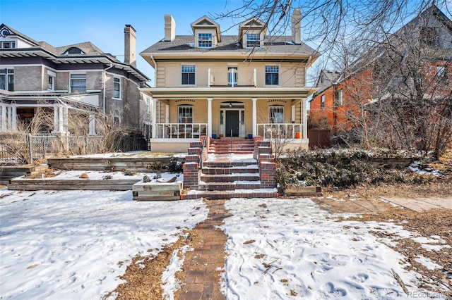 american foursquare style home featuring covered porch