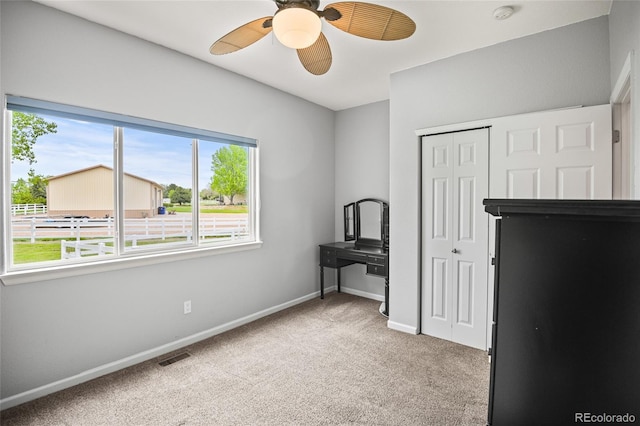 bedroom featuring multiple windows, ceiling fan, and light colored carpet