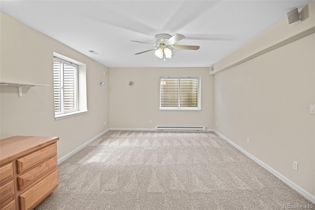 carpeted spare room with a baseboard heating unit and ceiling fan