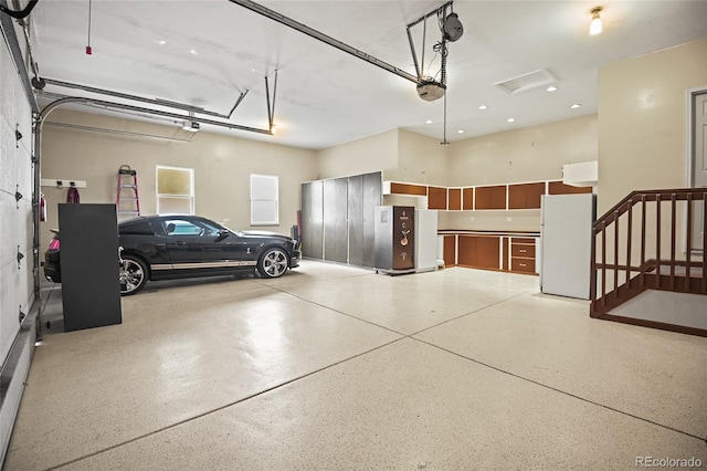 garage with a garage door opener and white refrigerator