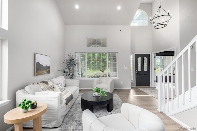 664 Clarendon Dr, Longmont, CO 80504 - living room with high vaulted ceiling, a chandelier, wood finished floors, and stairway