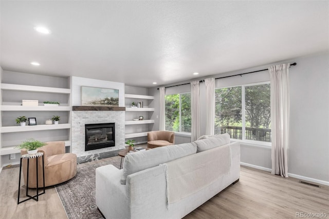 664 Clarendon Dr, Longmont, CO 80504 - living area featuring a glass covered fireplace, light wood-type flooring, and recessed lighting