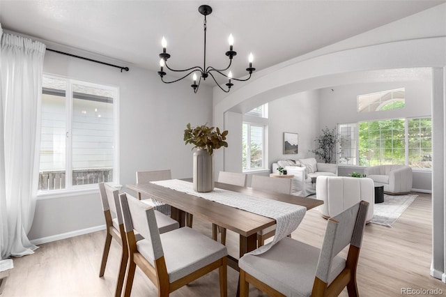 664 Clarendon Dr, Longmont, CO 80504 - dining area with light wood finished floors, arched walkways, and a chandelier