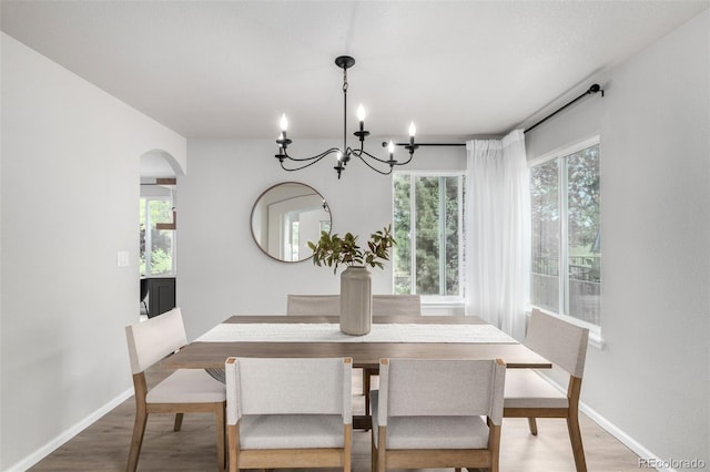 664 Clarendon Dr, Longmont, CO 80504 - dining space featuring wood finished floors, arched walkways, and plenty of natural light