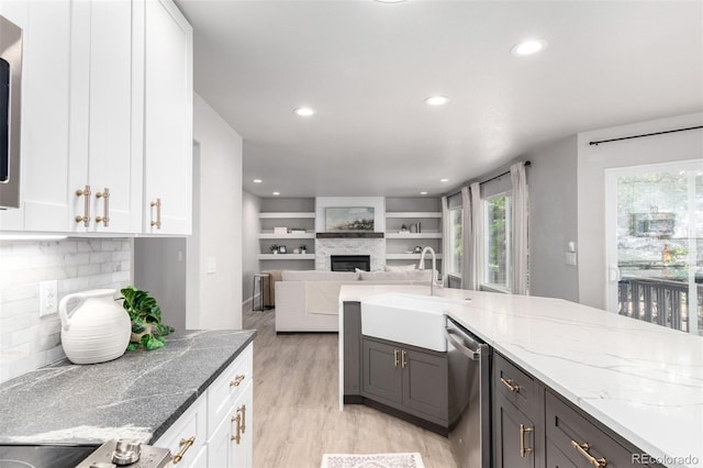 664 Clarendon Dr, Longmont, CO 80504 - kitchen featuring stainless steel dishwasher, light wood-style flooring, white cabinets, a fireplace, and recessed lighting