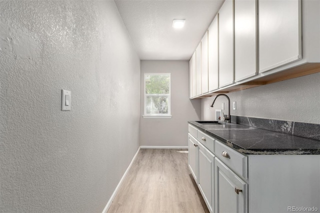664 Clarendon Dr, Longmont, CO 80504 - laundry area featuring cabinet space, a textured wall, light wood-type flooring, and washer hookup