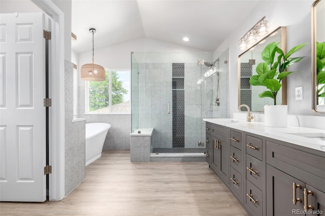 664 Clarendon Dr, Longmont, CO 80504 - bathroom featuring a stall shower, double vanity, a soaking tub, lofted ceiling, and wood finished floors