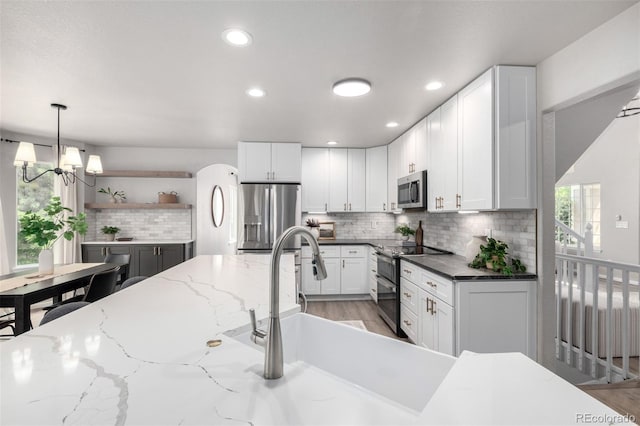 664 Clarendon Dr, Longmont, CO 80504 - kitchen featuring stainless steel appliances, backsplash, white cabinets, recessed lighting, and decorative light fixtures