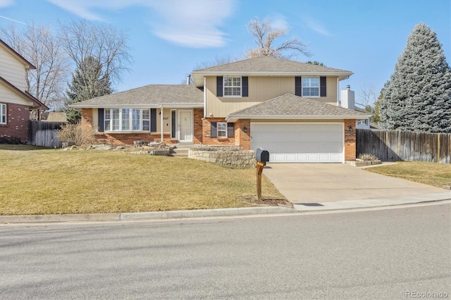 tri-level home featuring a front lawn, fence, brick siding, and driveway