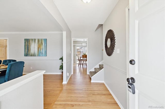 foyer entrance featuring baseboards and light wood finished floors