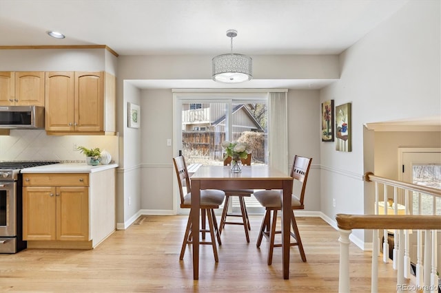 dining area with light wood finished floors and baseboards