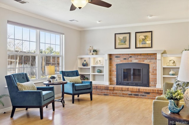 sitting room featuring visible vents, ornamental molding, and wood finished floors