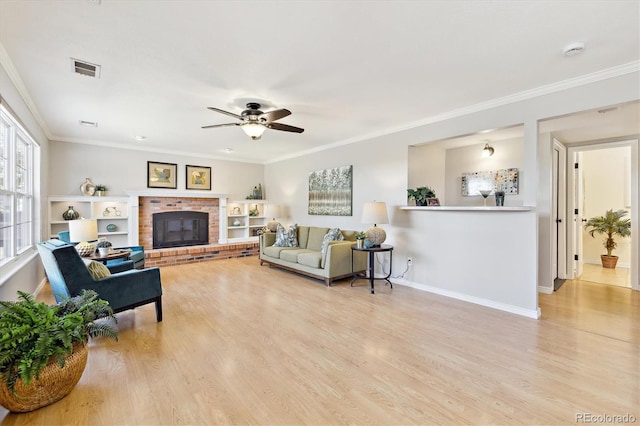 living area featuring a brick fireplace, light wood-style flooring, crown molding, and baseboards